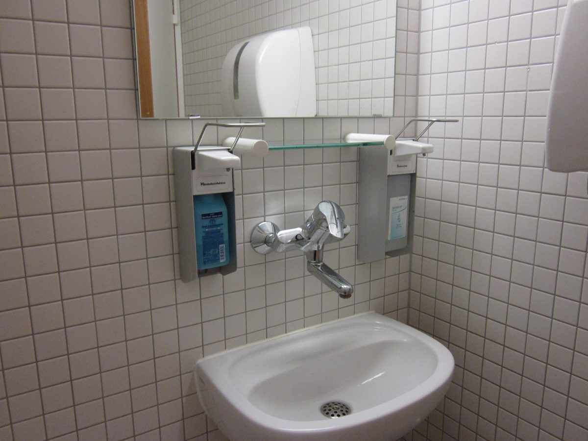 Washroom hygiene services equipment: wall-mounted soap and paper towel dispensers above a washbasin